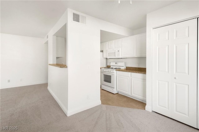 2801 N Rainbow Blvd Unit 235, Las Vegas, NV 89108 - kitchen featuring white appliances, light carpet, white cabinets, and dark countertops