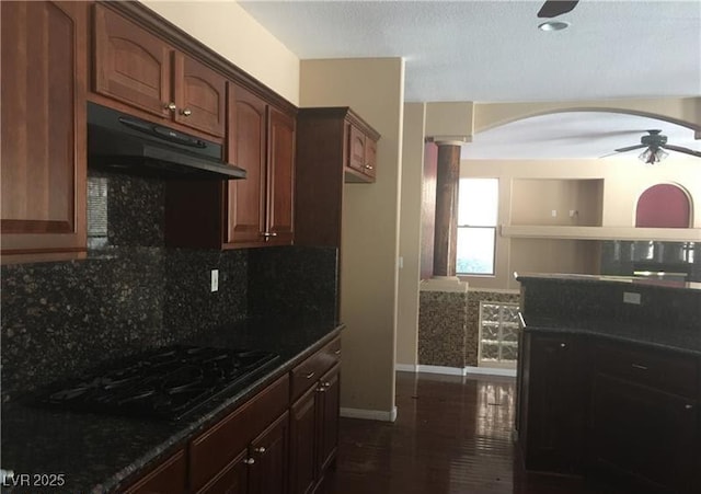 7414 Page Ranch Ct, Las Vegas, NV 89131 - kitchen featuring under cabinet range hood, ceiling fan, black stovetop, arched walkways, and backsplash