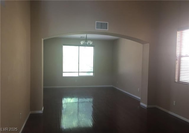 7414 Page Ranch Ct, Las Vegas, NV 89131 - unfurnished room with arched walkways, a chandelier, and wood finished floors