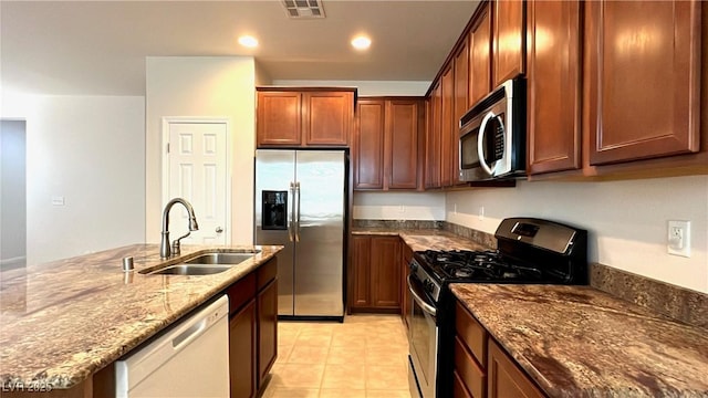 7469 Paces Mill Ct, Las Vegas, NV 89113 - kitchen with stainless steel appliances, dark stone countertops, an island with sink, recessed lighting, and light tile patterned floors