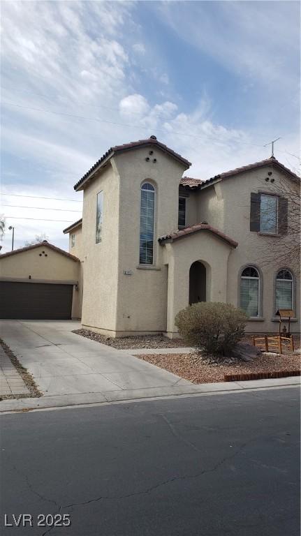 6117 Glenborough St, Las Vegas, NV 89115 - mediterranean / spanish-style home featuring stucco siding, a tiled roof, an outbuilding, and a garage