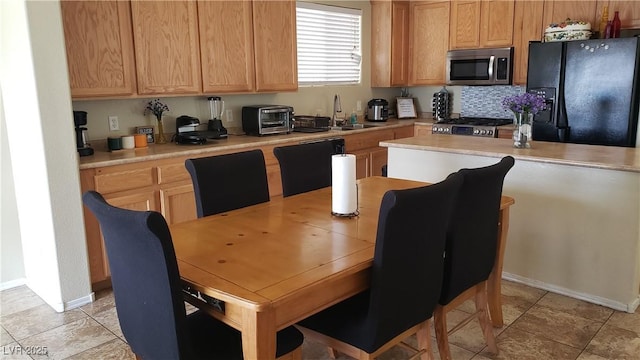 6117 Glenborough St, Las Vegas, NV 89115 - kitchen featuring stainless steel microwave, black refrigerator with ice dispenser, stove, and light countertops