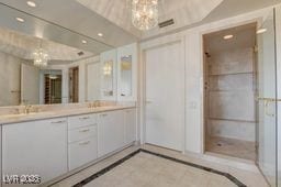 2877 Paradise Rd Unit 904, Las Vegas, NV 89109 - full bathroom with a chandelier, inlaid floor details, double vanity, and recessed lighting