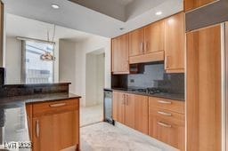 2877 Paradise Rd Unit 904, Las Vegas, NV 89109 - kitchen with backsplash, dark countertops, recessed lighting, under cabinet range hood, and hanging light fixtures