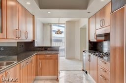 2877 Paradise Rd Unit 904, Las Vegas, NV 89109 - kitchen featuring decorative backsplash, recessed lighting, light marble finish floors, and a raised ceiling