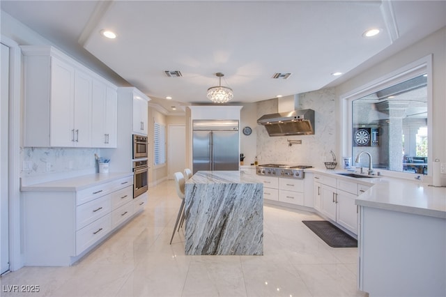 1890 Pago Ct, Las Vegas, NV 89117 - kitchen featuring stainless steel appliances, wall chimney range hood, backsplash, a kitchen island, and recessed lighting