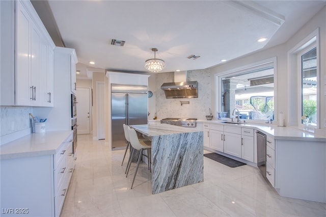 1890 Pago Ct, Las Vegas, NV 89117 - kitchen with exhaust hood, appliances with stainless steel finishes, backsplash, white cabinets, and recessed lighting