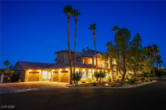 1890 Pago Ct, Las Vegas, NV 89117 - view of front facade featuring decorative driveway, an attached garage, stucco siding, and a chimney