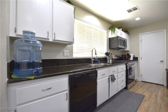 6628 Ives Ave, Las Vegas, NV 89108 - kitchen featuring stainless steel appliances, white cabinetry, dark countertops, light wood-type flooring, and recessed lighting