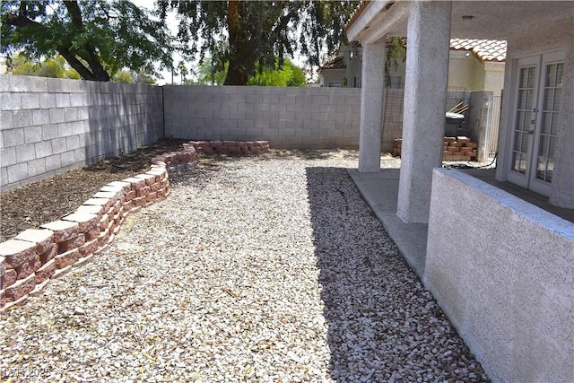 6628 Ives Ave, Las Vegas, NV 89108 - fenced backyard with french doors and a patio area