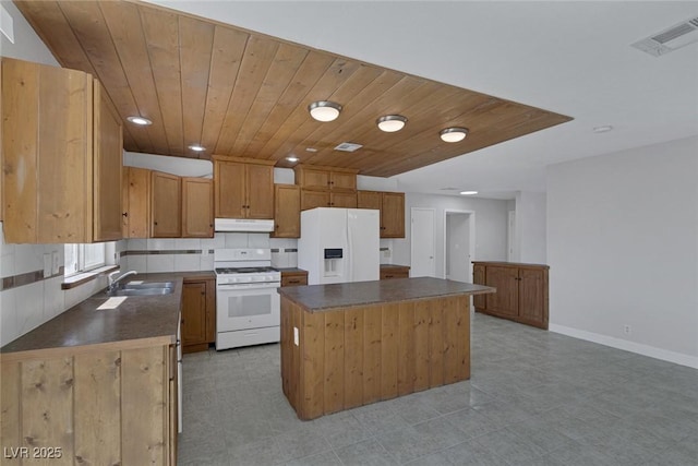 1841 Feather Way, Las Vegas, NV 89108 - kitchen with white appliances, under cabinet range hood, dark countertops, a kitchen island, and wooden ceiling