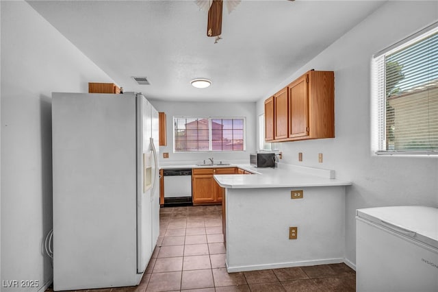 2165 Saint Paul Way, Las Vegas, NV 89104 - kitchen featuring white appliances, light countertops, tile patterned flooring, a peninsula, and brown cabinets