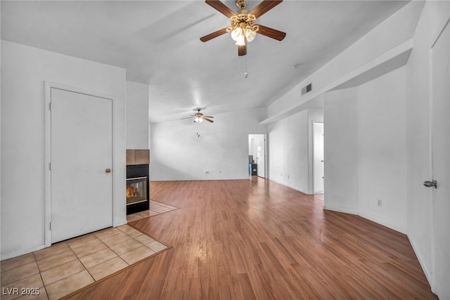 2165 Saint Paul Way, Las Vegas, NV 89104 - unfurnished living room featuring ceiling fan, a tiled fireplace, and wood finished floors