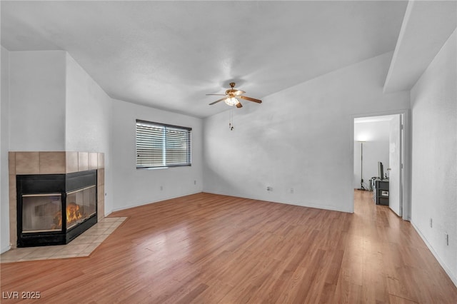 2165 Saint Paul Way, Las Vegas, NV 89104 - unfurnished living room with light wood-type flooring, a tile fireplace, and ceiling fan