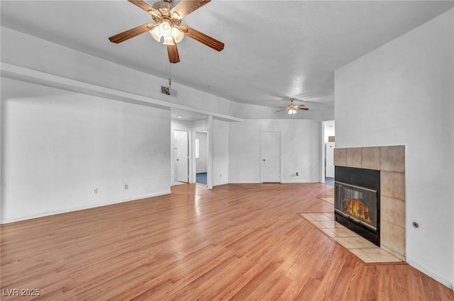 2165 Saint Paul Way, Las Vegas, NV 89104 - unfurnished living room featuring a ceiling fan, light wood-style floors, and a tile fireplace
