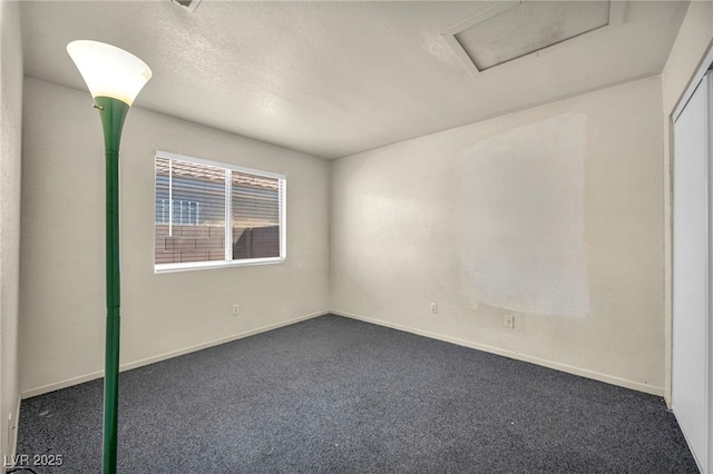 2165 Saint Paul Way, Las Vegas, NV 89104 - unfurnished room with attic access, dark carpet, and a textured ceiling