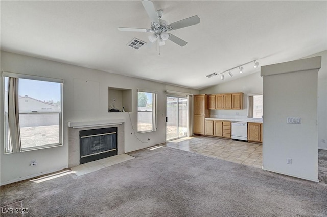 5917 Briar Rose Ln, Las Vegas, NV 89130 - unfurnished living room featuring a tiled fireplace, ceiling fan, vaulted ceiling, light colored carpet, and rail lighting
