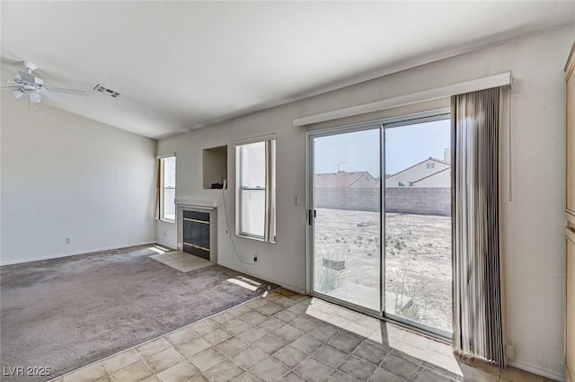 5917 Briar Rose Ln, Las Vegas, NV 89130 - unfurnished living room featuring healthy amount of natural light, a fireplace, a ceiling fan, and light colored carpet