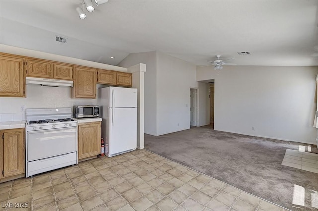 5917 Briar Rose Ln, Las Vegas, NV 89130 - kitchen featuring white appliances, tile counters, under cabinet range hood, light colored carpet, and lofted ceiling