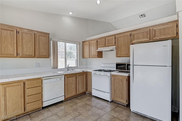 5917 Briar Rose Ln, Las Vegas, NV 89130 - kitchen with white appliances, under cabinet range hood, vaulted ceiling, light countertops, and recessed lighting
