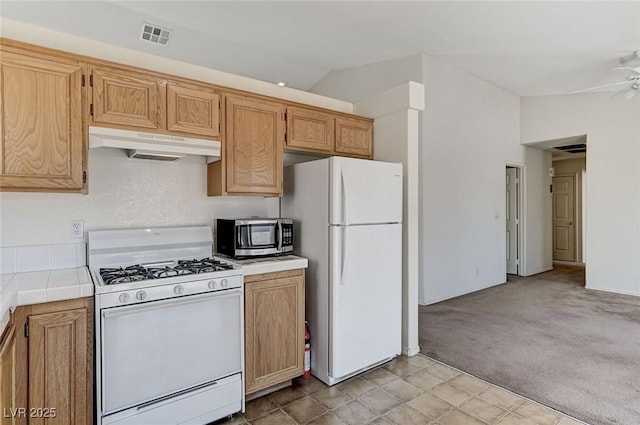 5917 Briar Rose Ln, Las Vegas, NV 89130 - kitchen featuring white appliances, under cabinet range hood, tile counters, ceiling fan, and light carpet
