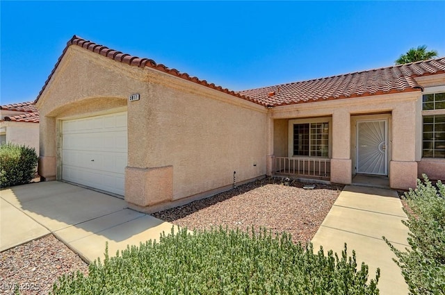 5917 Briar Rose Ln, Las Vegas, NV 89130 - view of exterior entry with a tiled roof, an attached garage, stucco siding, and driveway