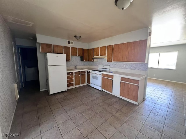 6120 Denver Cir, Las Vegas, NV 89107 - kitchen with white appliances, under cabinet range hood, tile countertops, and dark tile patterned floors