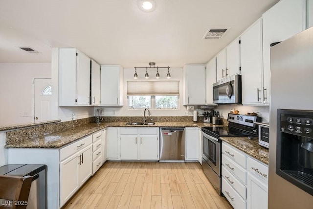 6140 Atwood Ave, Las Vegas, NV 89108 - kitchen with stainless steel appliances, white cabinets, and dark stone countertops