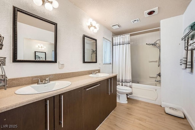 6140 Atwood Ave, Las Vegas, NV 89108 - bathroom featuring wood finished floors, shower / tub combo with curtain, double vanity, and a textured ceiling
