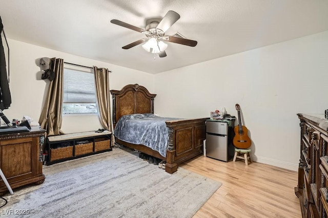 6140 Atwood Ave, Las Vegas, NV 89108 - bedroom with freestanding refrigerator, light wood-type flooring, and a ceiling fan