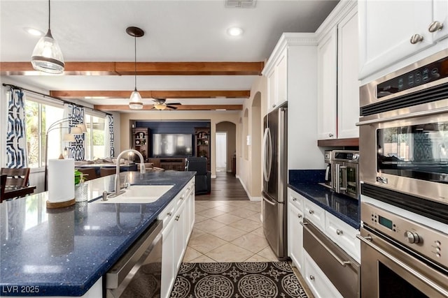 9380 Arrowhead Bluff Ave, Las Vegas, NV 89149 - kitchen with stainless steel appliances, arched walkways, open floor plan, white cabinets, and light tile patterned flooring