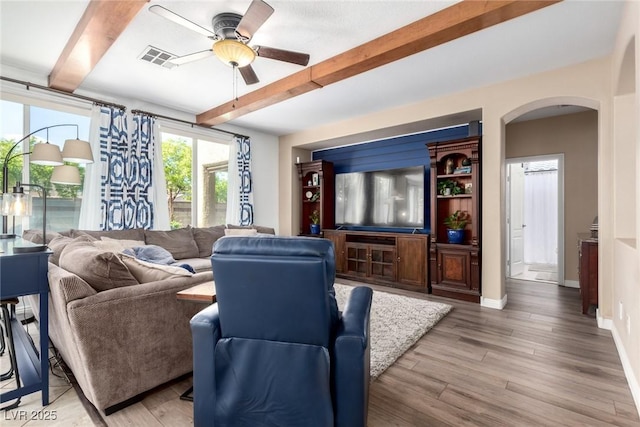 9380 Arrowhead Bluff Ave, Las Vegas, NV 89149 - living room featuring beam ceiling, arched walkways, a ceiling fan, and light wood-type flooring