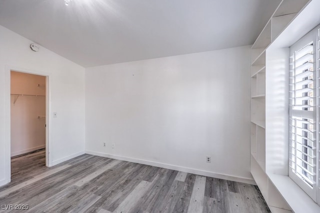 5320 Castle Harbor Ave, Las Vegas, NV 89130 - empty room with wood finished floors, plenty of natural light, a smoke detector, and lofted ceiling