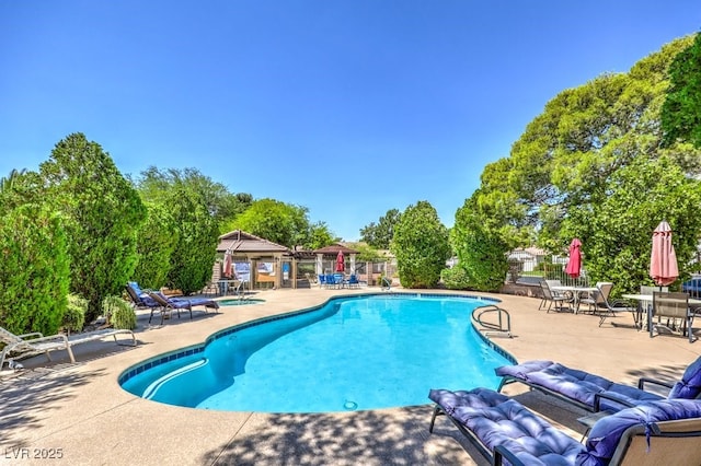 5320 Castle Harbor Ave, Las Vegas, NV 89130 - community pool with a patio, outdoor lounge area, and view of scattered trees
