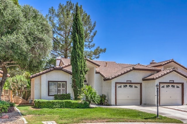 5320 Castle Harbor Ave, Las Vegas, NV 89130 - mediterranean / spanish home featuring a garage, stucco siding, driveway, and a tile roof