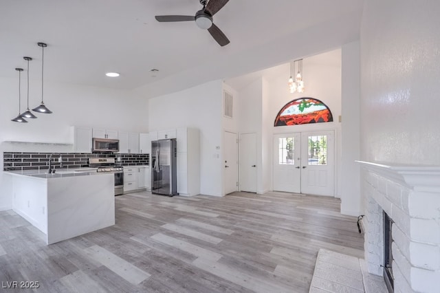 5320 Castle Harbor Ave, Las Vegas, NV 89130 - kitchen featuring appliances with stainless steel finishes, high vaulted ceiling, a ceiling fan, pendant lighting, and white cabinetry