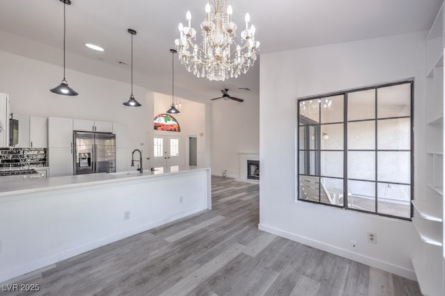 5320 Castle Harbor Ave, Las Vegas, NV 89130 - kitchen with appliances with stainless steel finishes, white cabinets, a fireplace, ceiling fan, and light countertops
