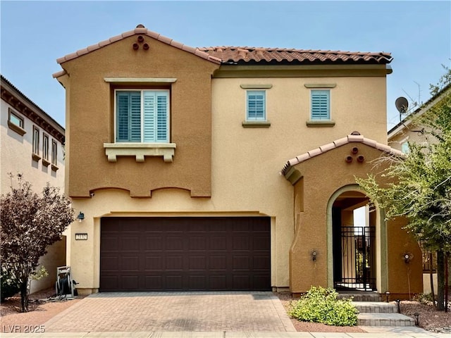 2132 Solvang Mill Dr, Las Vegas, NV 89135 - mediterranean / spanish home featuring a garage, stucco siding, decorative driveway, and a tile roof