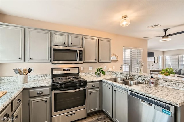 3125 N Buffalo Dr Unit 1090, Las Vegas, NV 89128 - kitchen with appliances with stainless steel finishes, a peninsula, gray cabinetry, a ceiling fan, and dark wood finished floors