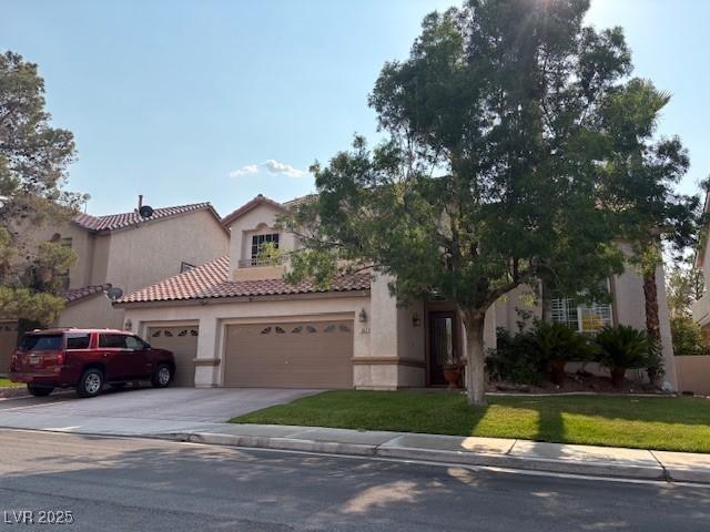 302 Doe Run, Henderson, NV 89012 - mediterranean / spanish house with a garage, stucco siding, concrete driveway, a front yard, and a tiled roof
