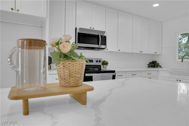1317 Pyramid Dr, Las Vegas, NV 89108 - kitchen featuring appliances with stainless steel finishes, white cabinets, light stone countertops, and recessed lighting