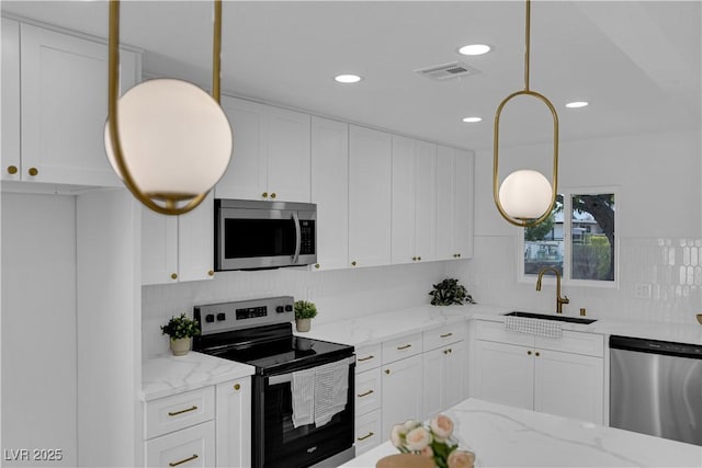 1317 Pyramid Dr, Las Vegas, NV 89108 - kitchen with appliances with stainless steel finishes, backsplash, white cabinetry, light stone countertops, and recessed lighting