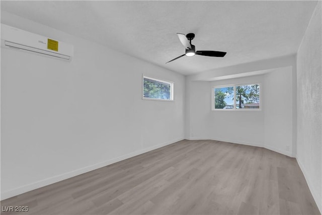 1317 Pyramid Dr, Las Vegas, NV 89108 - unfurnished room featuring a wall mounted AC, light wood-style floors, and ceiling fan