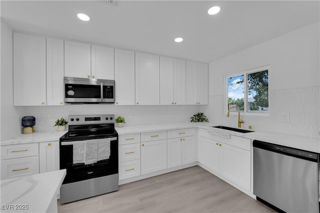 1317 Pyramid Dr, Las Vegas, NV 89108 - kitchen featuring stainless steel appliances, light stone counters, decorative backsplash, white cabinets, and recessed lighting