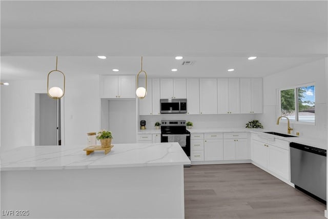 1317 Pyramid Dr, Las Vegas, NV 89108 - kitchen featuring appliances with stainless steel finishes, light stone counters, white cabinetry, recessed lighting, and hanging light fixtures