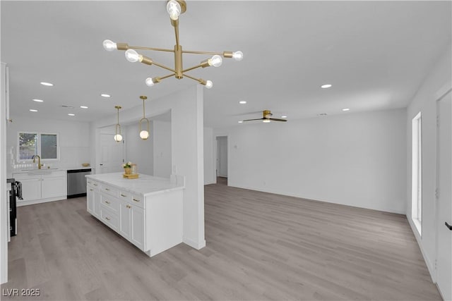 1317 Pyramid Dr, Las Vegas, NV 89108 - kitchen featuring stainless steel dishwasher, white cabinets, a chandelier, light wood-style flooring, and ceiling fan