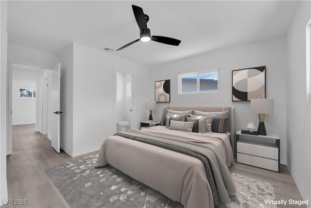 1317 Pyramid Dr, Las Vegas, NV 89108 - bedroom featuring multiple windows, wood finished floors, connected bathroom, and a ceiling fan