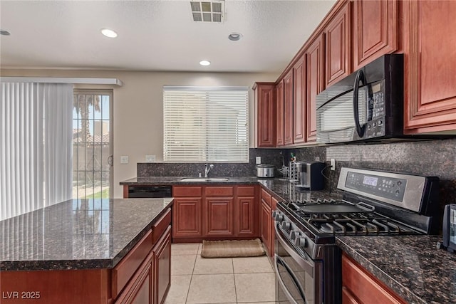 9221 Thunder Falls Ct, Las Vegas, NV 89149 - kitchen with black appliances, light tile patterned flooring, tasteful backsplash, dark stone countertops, and a kitchen island