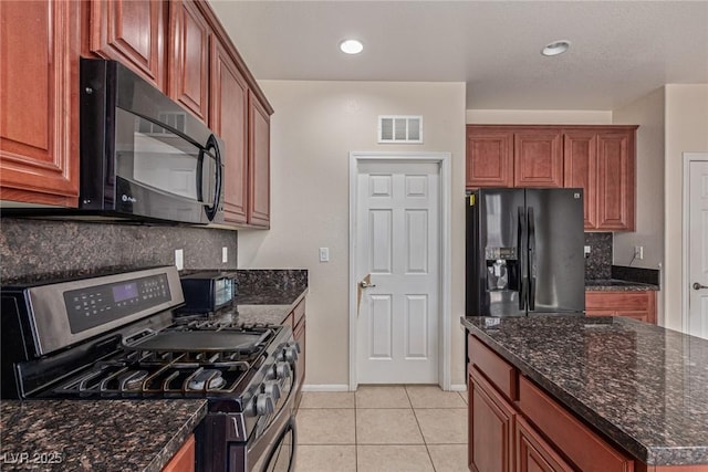 9221 Thunder Falls Ct, Las Vegas, NV 89149 - kitchen with black appliances, backsplash, light tile patterned floors, dark stone counters, and recessed lighting