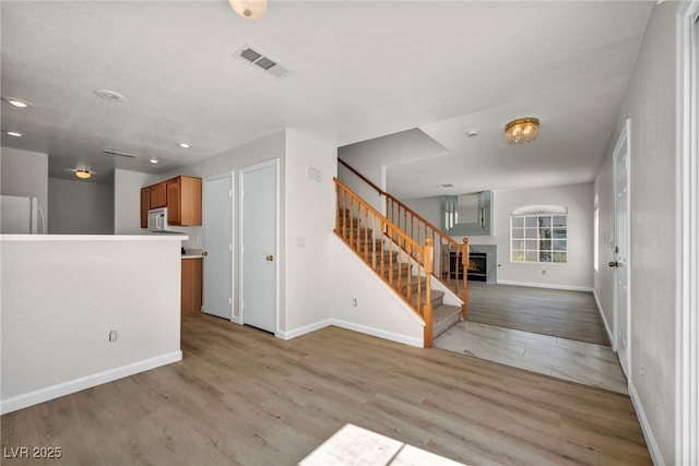 3448 Twilight Star Dr, Las Vegas, NV 89117 - entrance foyer featuring light wood-type flooring, stairway, recessed lighting, and a warm lit fireplace